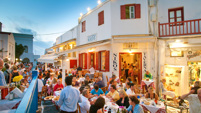 Diners sitting at tables of an outdoor Greek taverna