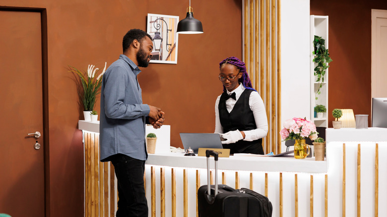 traveler talking to hotel receptionist