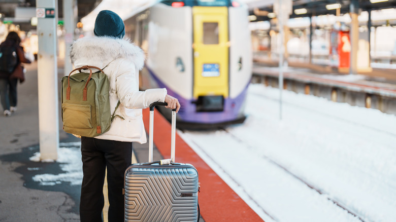 Woman with luggage waiting to board train