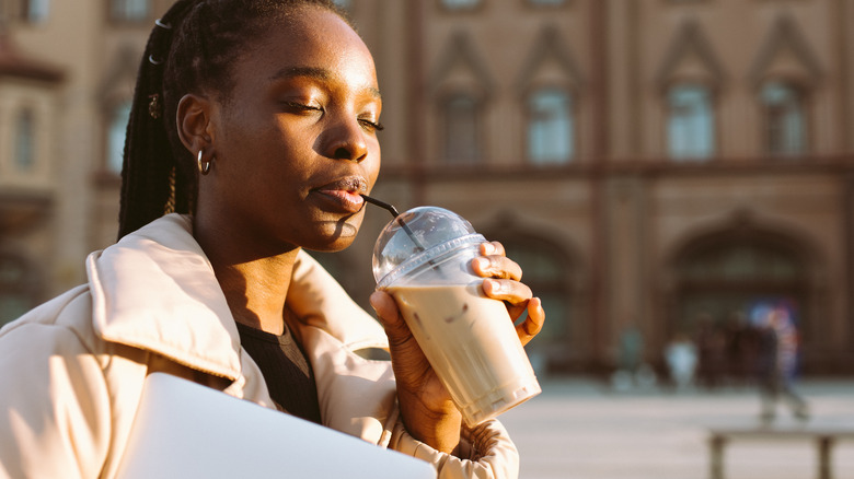 Young traveler sipping iced coffee