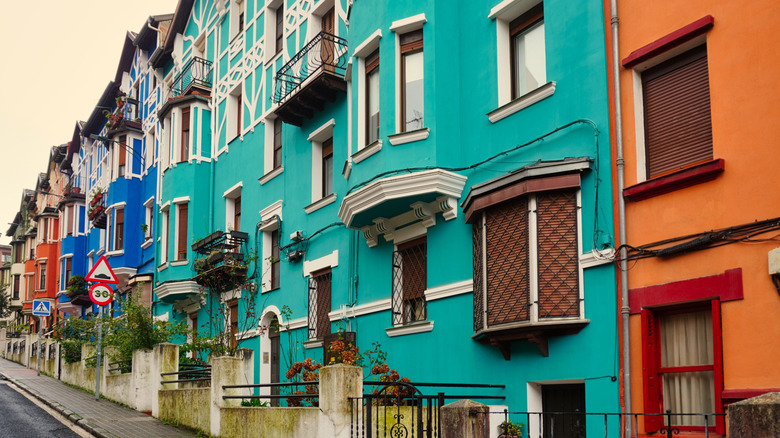 Colorful row houses line a street in Bilbao, Spain.