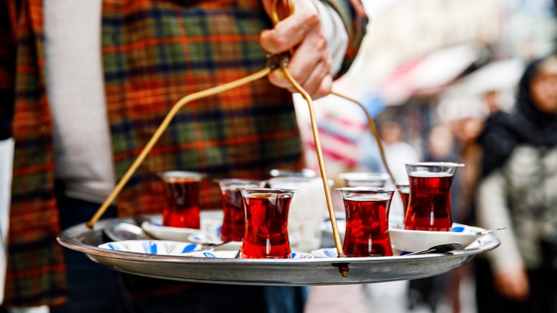 Vendor holding tray of Turkish tea