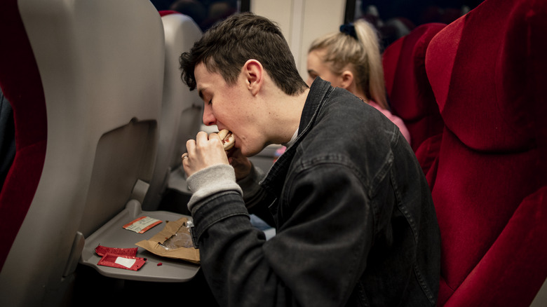 Man eating on board train 