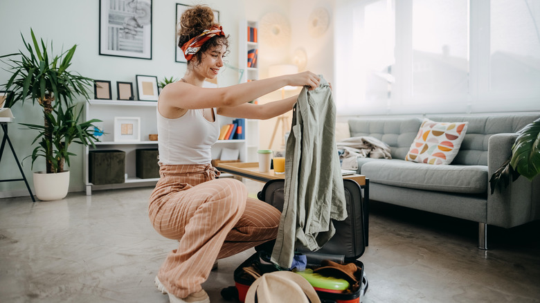 Woman packs suitcase