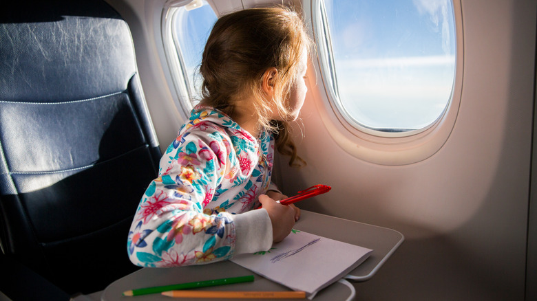 Child looking out plane window