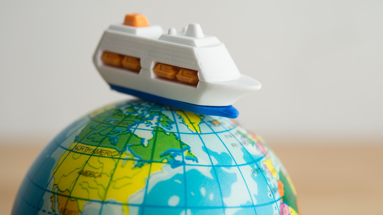 Toy cruise ship on toy globe