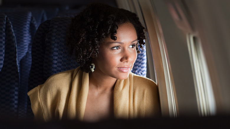 Woman looking out airplane window