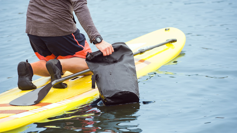 Paddler holding bag in water