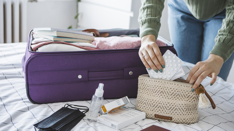 Woman packing medicine bag in hand luggage