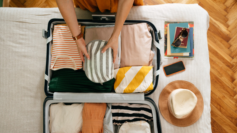 Woman packing clothes in suitcase