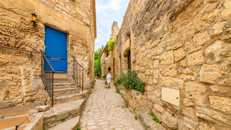 Woman walking through narrow cobblestone alley