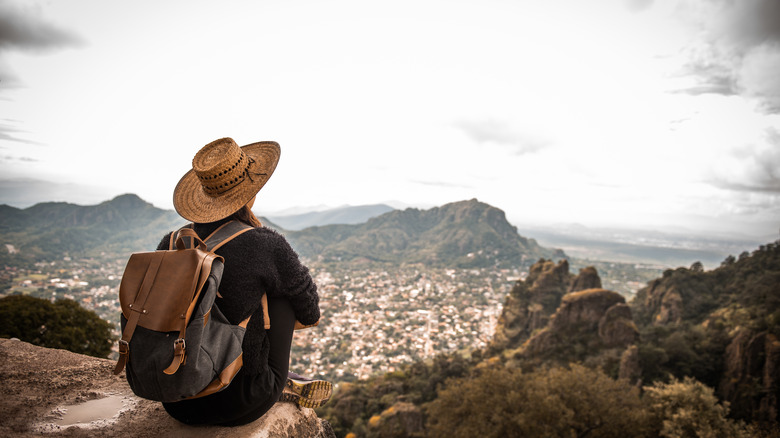 person with backpack overlooking mountains