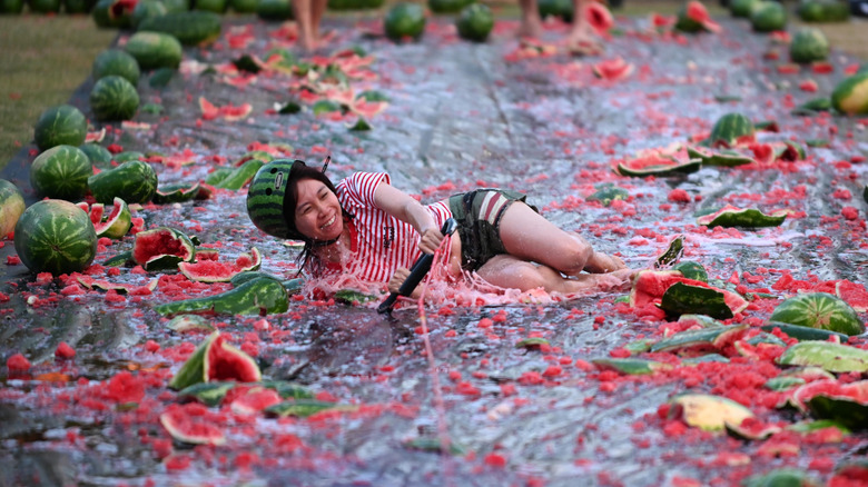 Person sliding through crushed watermelons
