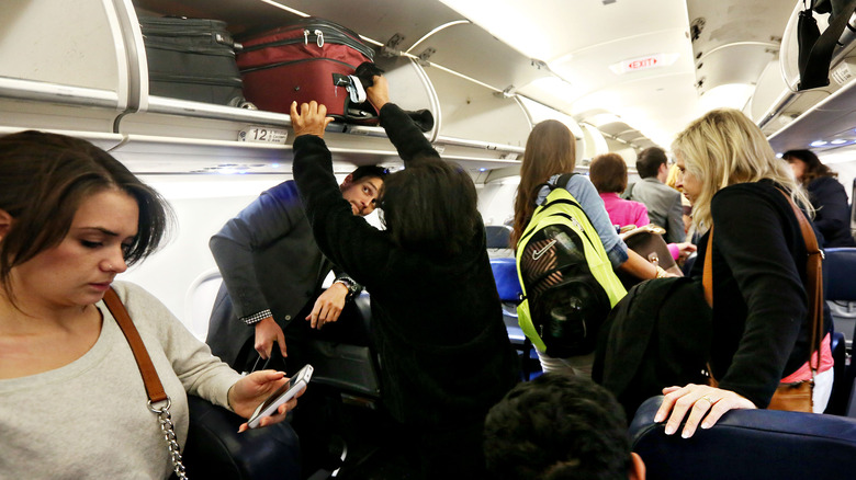 Passengers removing bags from bins