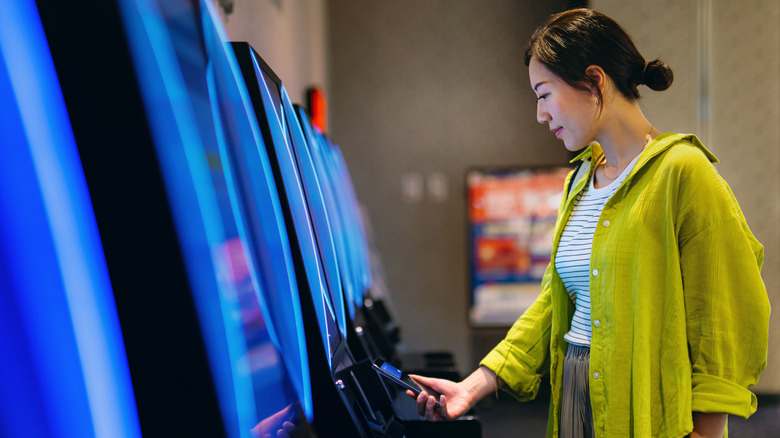 A woman using her phone to buy a movie ticket