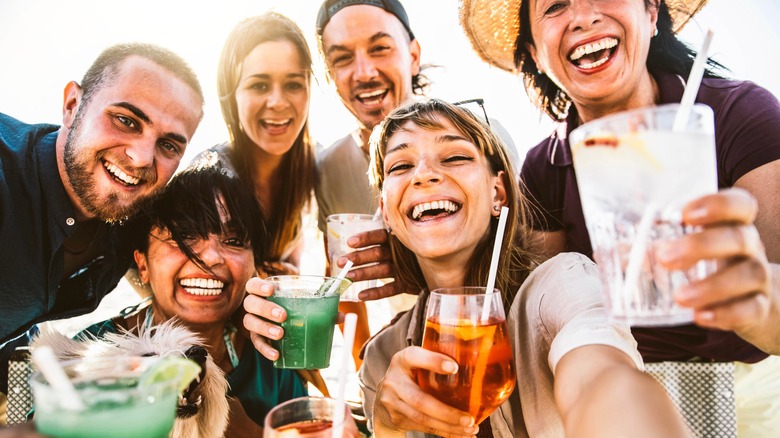 A group of friends taking a selfie while holding drinks