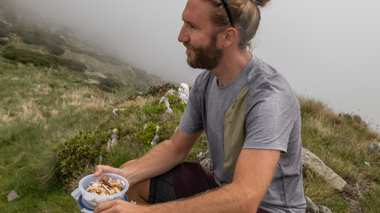 Hiker resting and eating trail mix