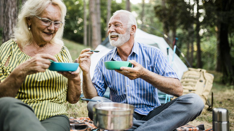 Senior hikers eating outdoors