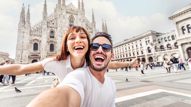 Couple taking selfie in front of Milano Duomo