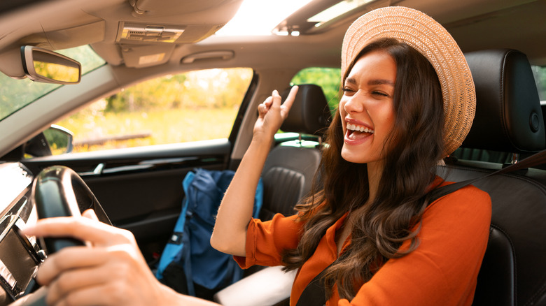 Happy woman driving a car and singing.