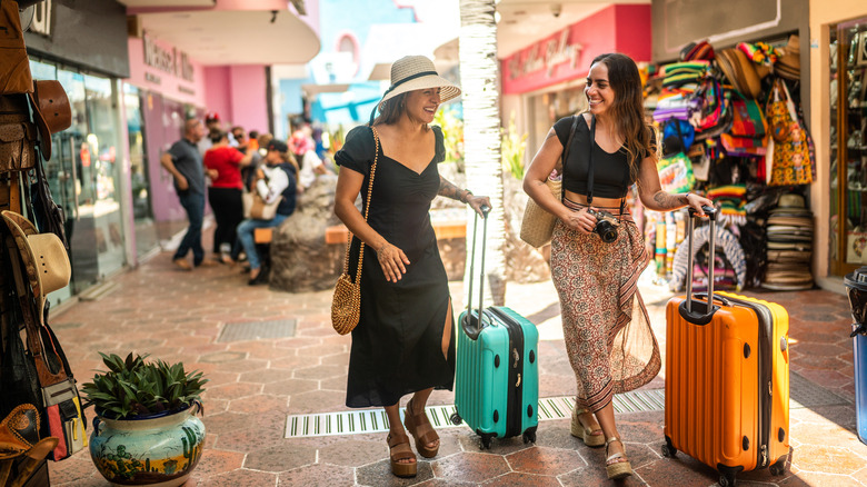 friends pushing suitcases in market