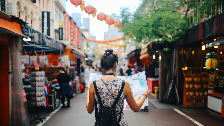 woman holding map in street