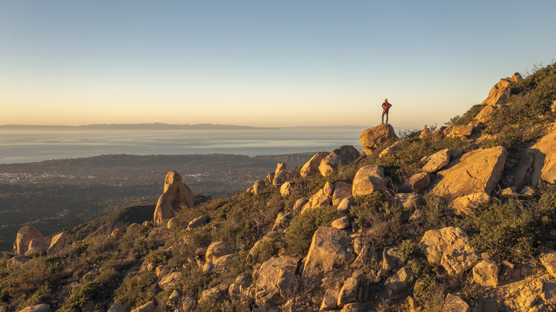 Hiker overlooking Santa Barbara, California, cliffside