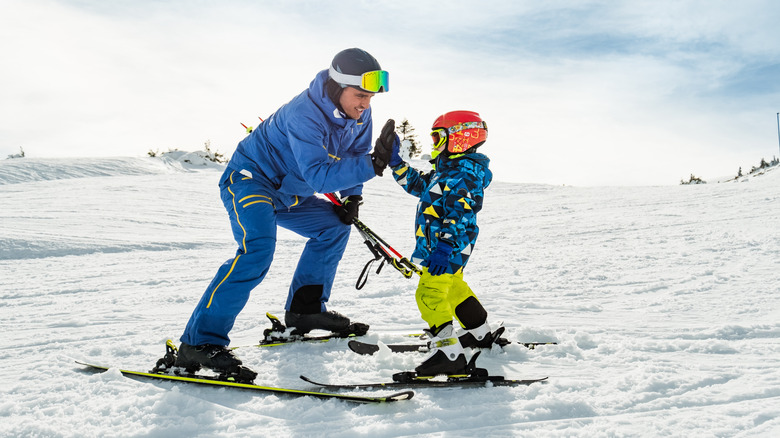 Boy learning to ski with instructor