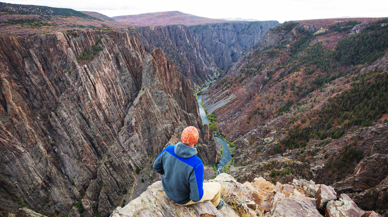 Hiker seated on the cliffs of Black Canyon of the Gunnison National Park