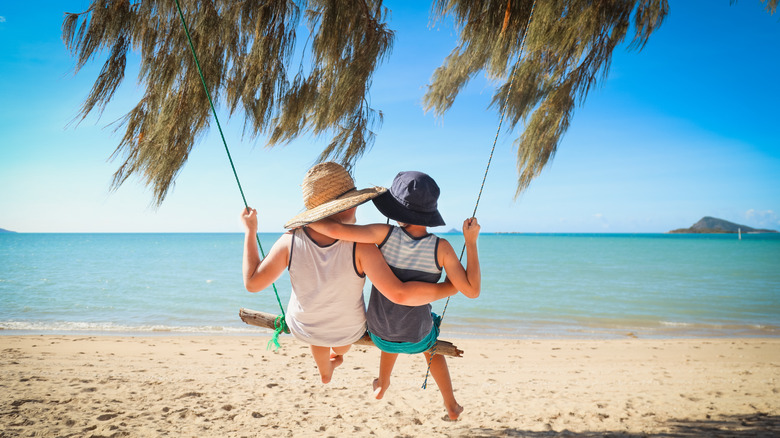 Children swinging at a beach