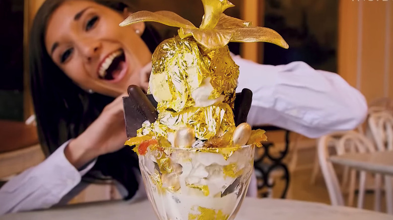 woman smiling behind golden dessert