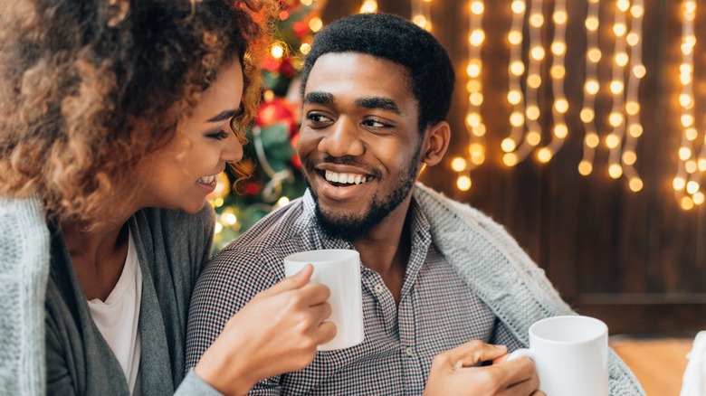 Couple laughing by festive lights