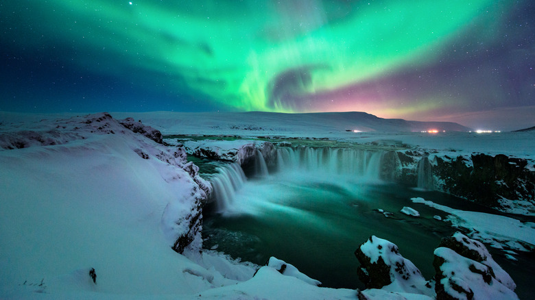 northern lights over Iceland waterfall