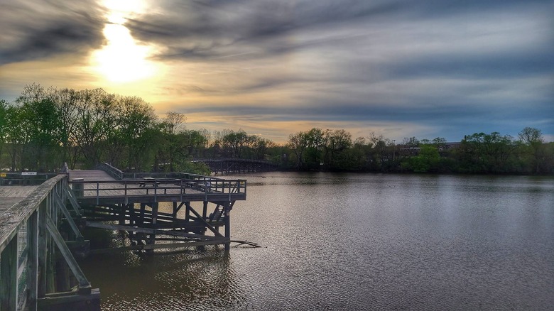 wooden jetty over water at sunset