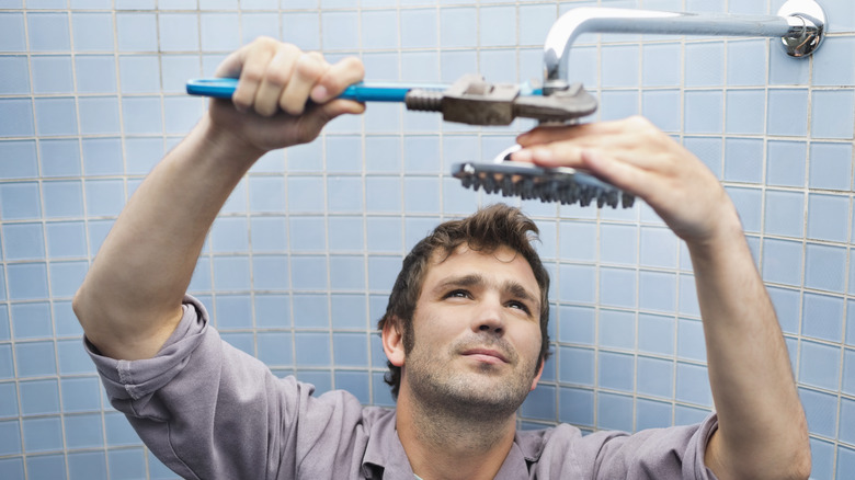 man removing showerhead