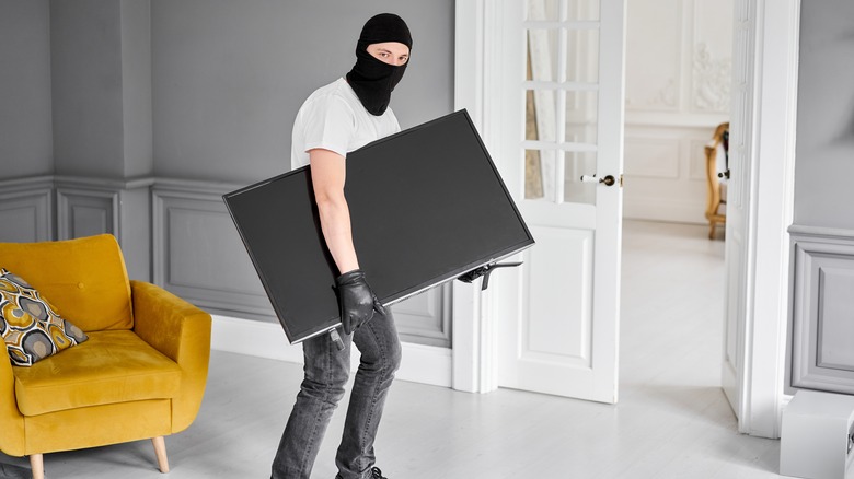 burglar holding TV