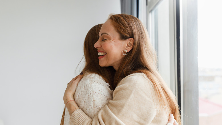 Two women greeting with a hug