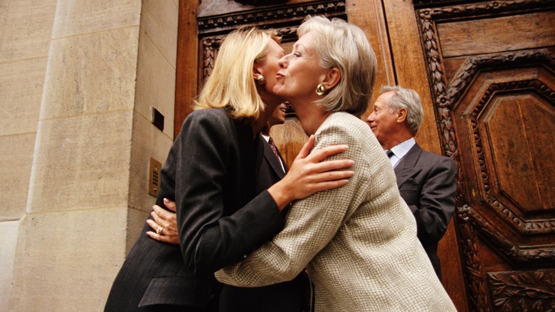 Two women greeting with a kiss