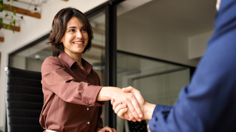 Woman and ma greeting professionally with a handshake