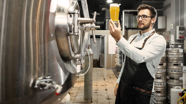 Factory worker looking at glass of beer