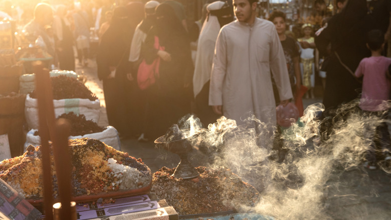 People walking by steaming cups in an Egyptian marketplace