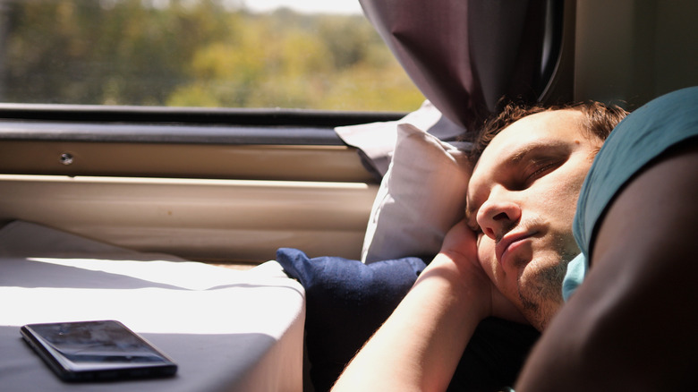 man sleeping on train