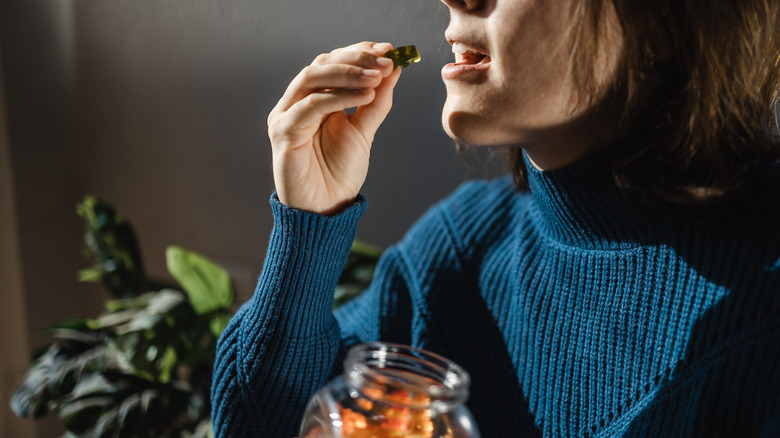 Woman eating marijuana-infused gummy