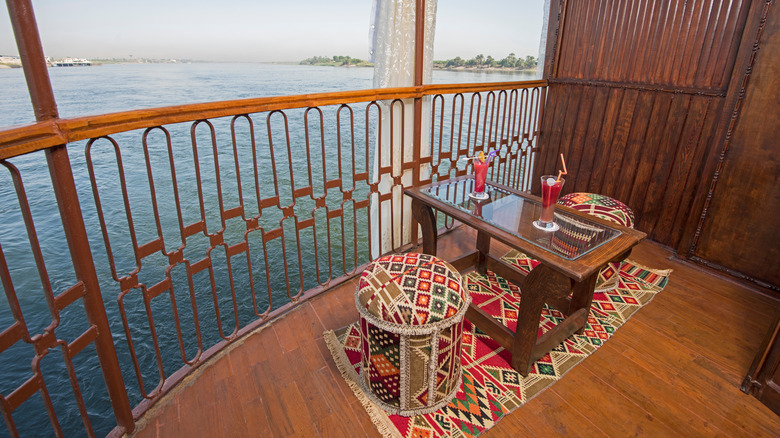 Cruise veranda with wooden table and tapestry seats
