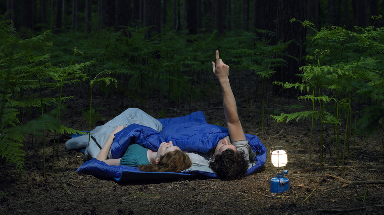 couple in sleeping bags in forest