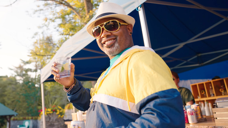 man in hat holding drink