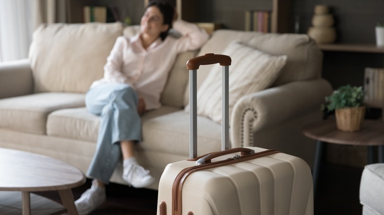 Suitcase and woman on sofa