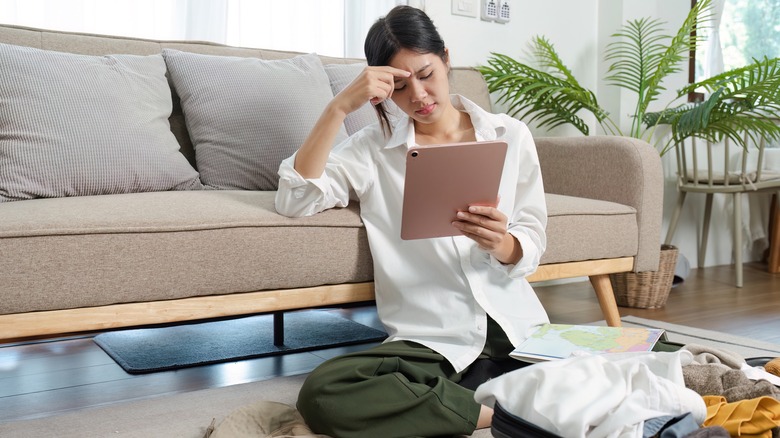 Woman with suitcase holding tablet