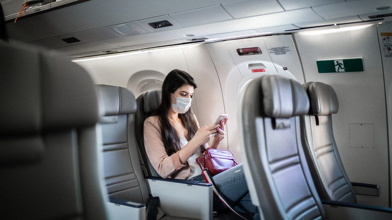 Passenger wearing face mask seated on airplane