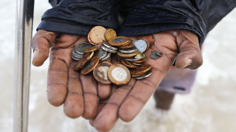 Two hands holding coins